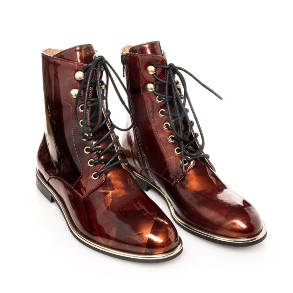 brown biker boots in patent leather with gold accents, photographed from above
